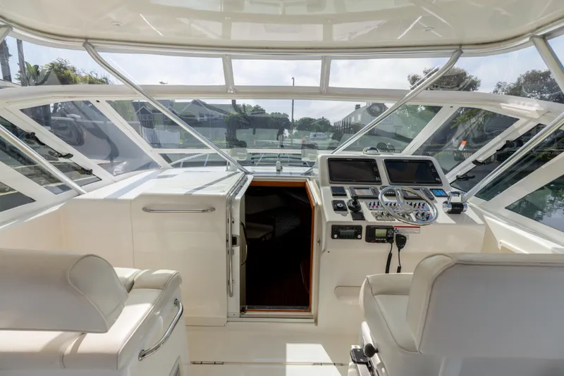 Slide: The Image of 2013 Cabo 36 Express boat cockpit with navigation controls and seating. - 13