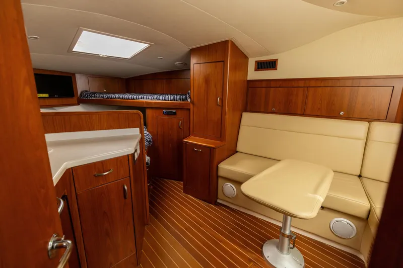 Slide: The Image of Interior of 2013 Cabo 36 Express boat with wood finish and beige seating. - 16
