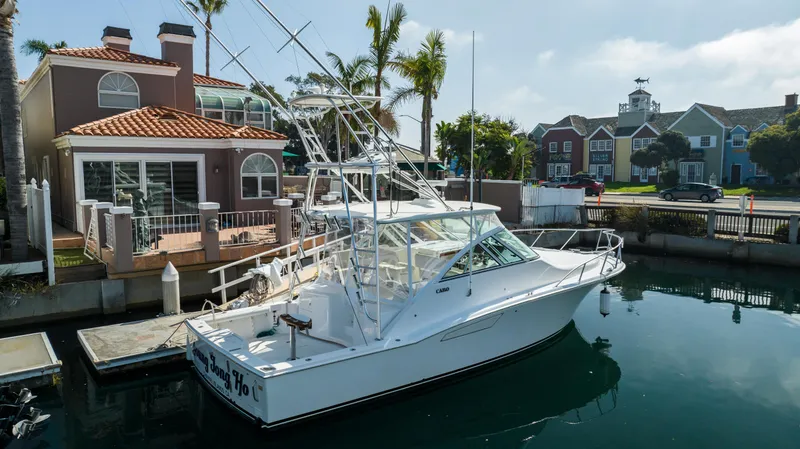 Slide: The Image of 2013 Cabo 36 Express boat docked near waterfront homes. - 2
