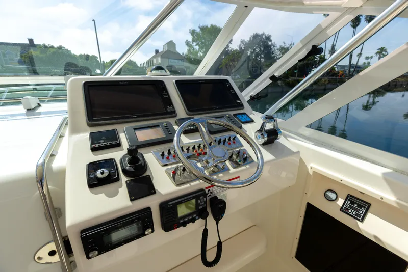 Slide: The Image of Control panel of a 2013 Cabo 36 Express boat with steering wheel and navigation equipment. - 27