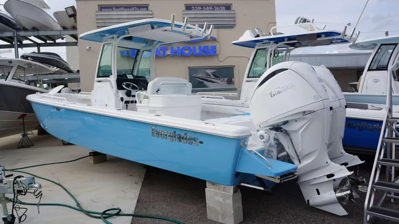 Slide: The Image of 2024 Everglades 273 CC boat with twin Yamaha engines at a dealership. - 1