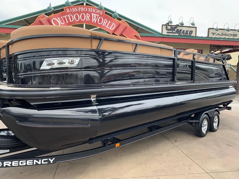 Slide: The Image of 2024 Regency 250 LE3 Sport pontoon boat displayed at Bass Pro Shops Outdoor World. - 2