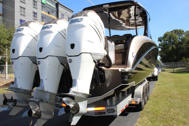 Slide: The Image of 2016 Mystic Powerboats M4200 with triple outboard engines on a trailer. - 10