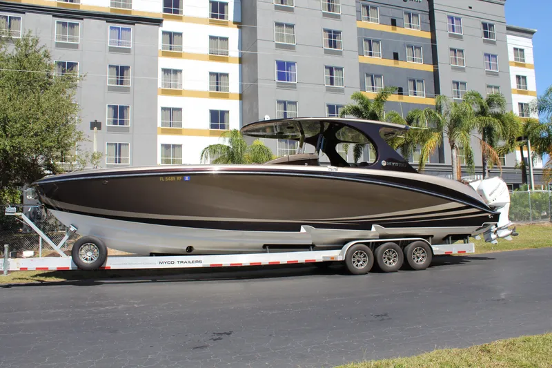 Slide: The Image of 2016 Mystic Powerboats M4200 on a trailer in front of a modern building. - 15