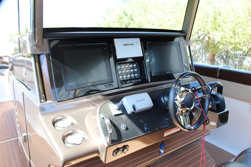 Slide: The Image of 2016 Mystic Powerboats M4200 dashboard with dual screens and steering wheel. - 30
