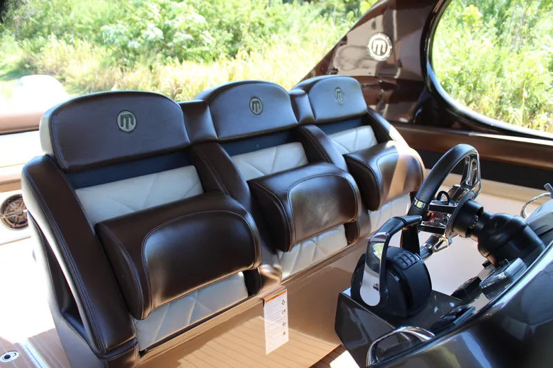 Slide: The Image of 2016 Mystic Powerboats M4200 cockpit with luxurious leather seating and advanced steering controls. - 31