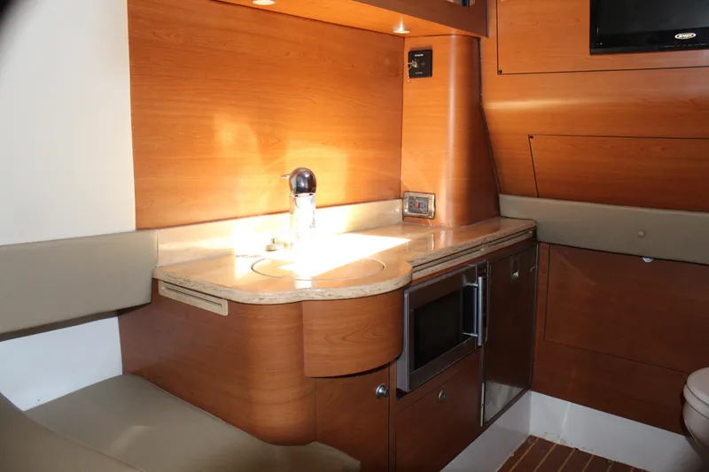 Slide: The Image of 2016 Mystic Powerboats M4200 interior kitchen area with wooden cabinetry and modern appliances. - 42