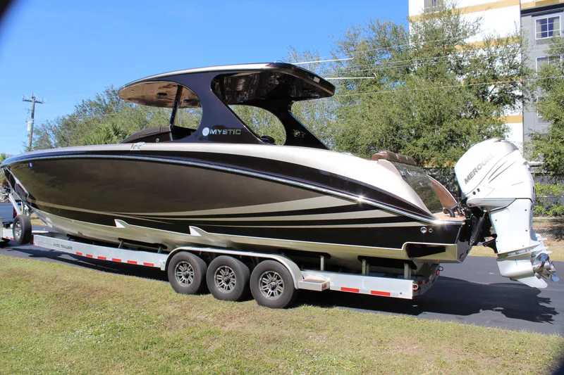 Slide: The Image of 2016 Mystic Powerboats M4200 on a trailer with triple outboard engines. - 6