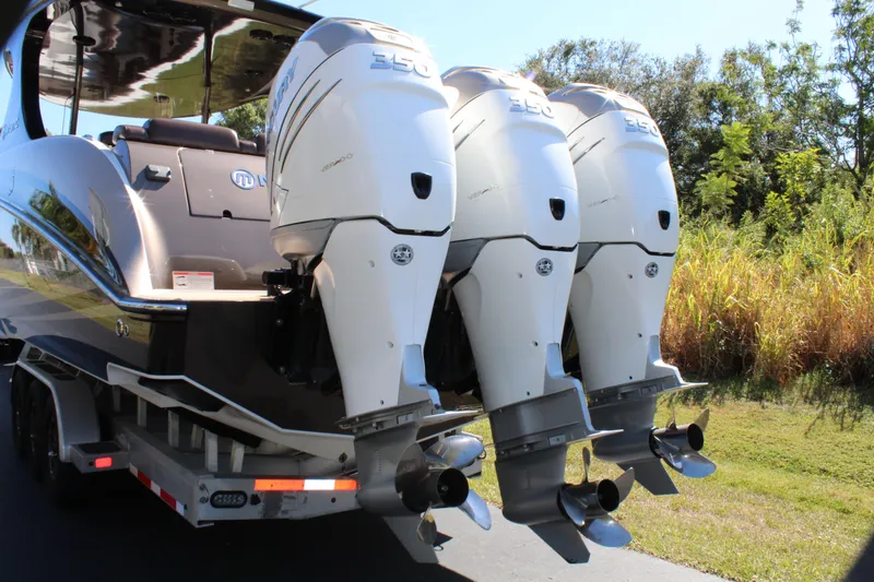 Slide: The Image of 2016 Mystic Powerboats M4200 with triple outboard engines on a trailer. - 8