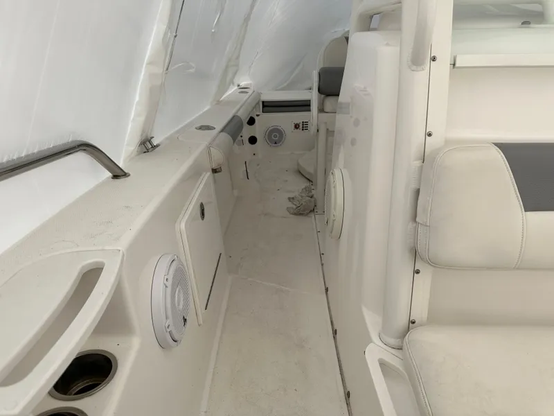 Slide: The Image of Interior view of 2018 Everglades 230CC boat, featuring white seating and built-in speakers. - 6