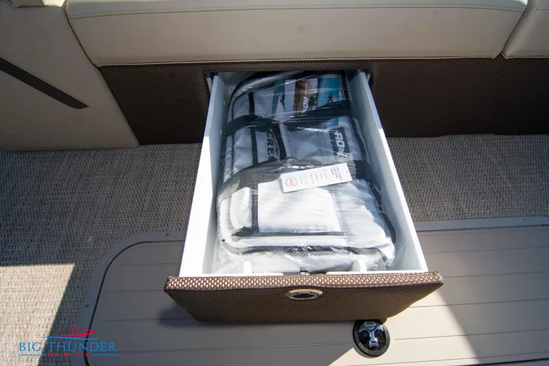 Slide: The Image of 2024 Crest Classic DLX 240 SLC storage compartment with life jackets. - 10