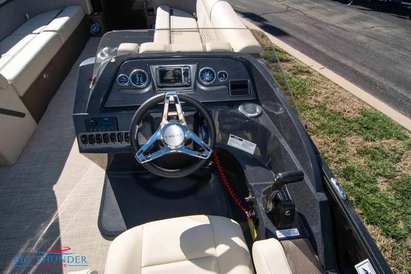 Slide: The Image of 2024 Crest Classic DLX 240 SLC boat dashboard with steering wheel and control panel. - 24