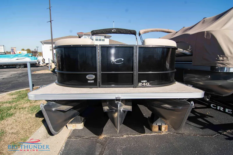 Slide: The Image of 2024 Crest Classic DLX 240 SLC pontoon boat displayed at a marina. - 3