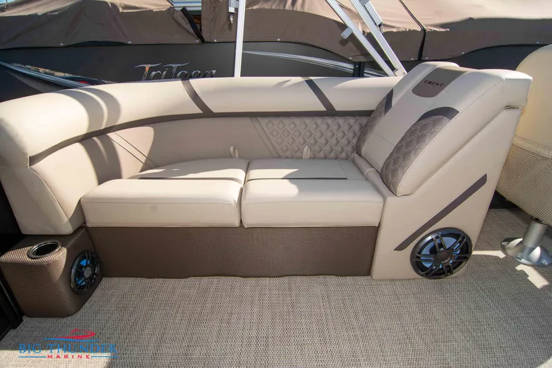 Slide: The Image of 2024 Crest Classic DLX 240 SLC boat interior with beige seating and built-in speakers. - 36