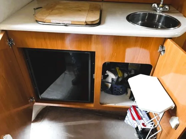 Slide: The Image of 2001 Regal 2960 Commodore Cruiser kitchen area with sink, cutting board, and storage cabinets. - 14