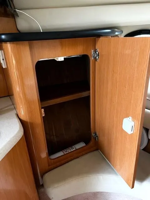Slide: The Image of Open wooden cabinet inside 2001 Regal 2960 Commodore Cruiser, showcasing interior shelving. - 28