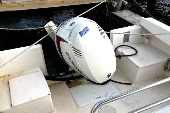 Slide: The Image of Outboard motor on a 1995 Parker 210 boat docked by the water. - 11