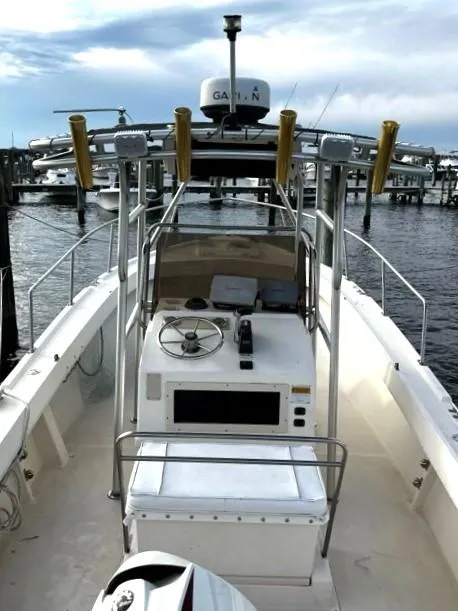 Slide: The Image of 1995 Parker 210 boat with Garmin equipment, docked at a marina under a cloudy sky. - 3