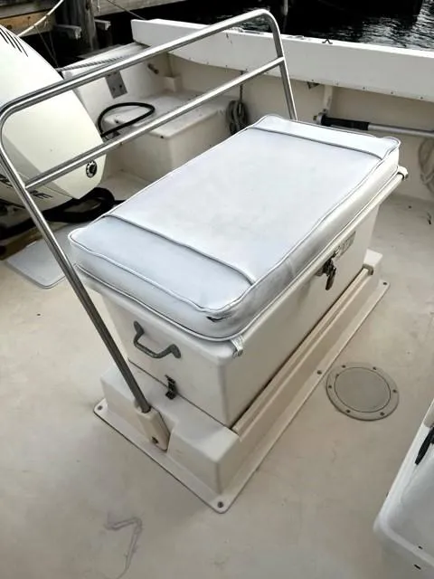 Slide: The Image of 1995 Parker 210 boat seat with storage, white cushion, and metal railing. - 9