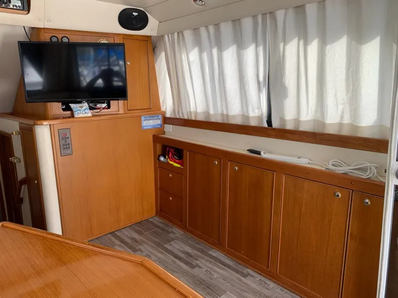 Slide: The Image of Interior of 2000 Riviera 34 Convertible with TV, wooden cabinets, and curtains. - 17