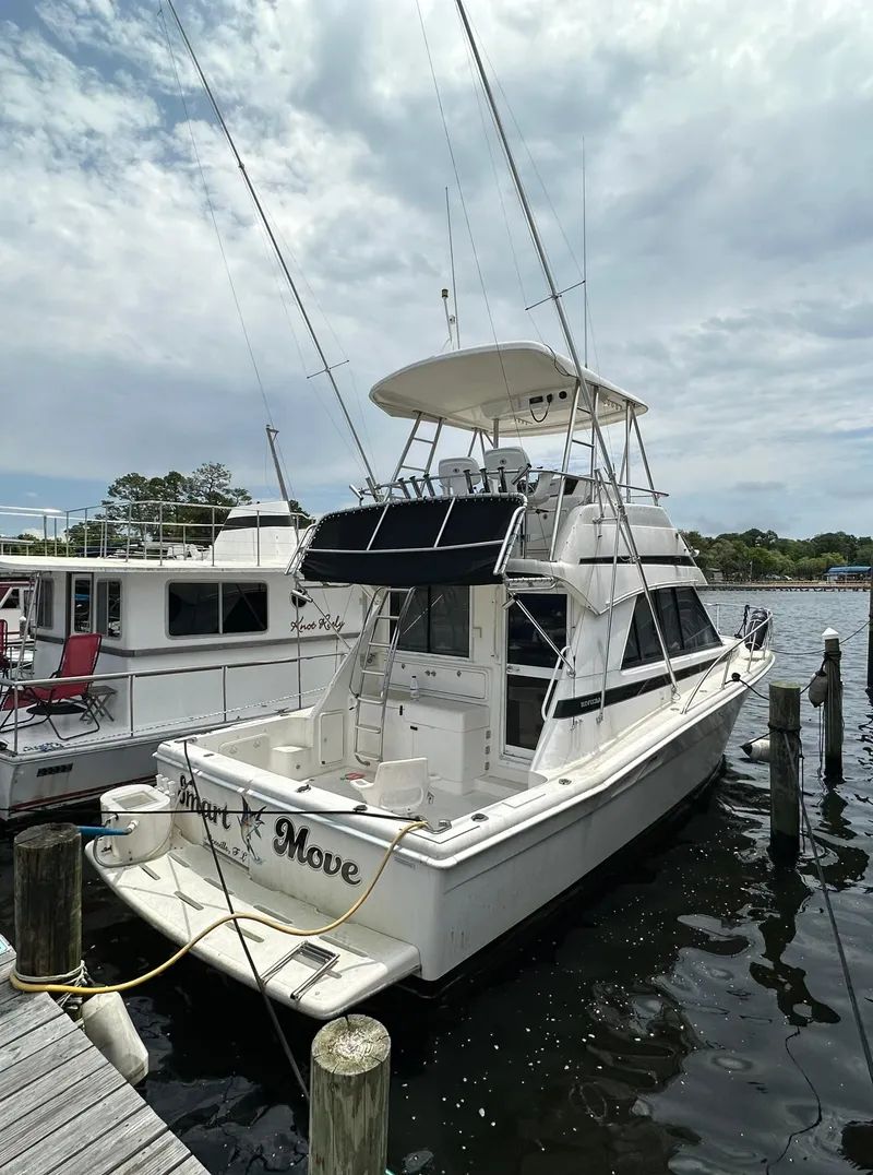 Slide: The Image of 2000 Riviera 34 Convertible yacht docked at a marina. - 2