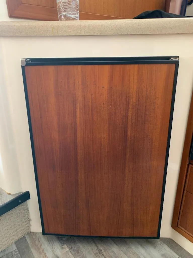 Slide: The Image of Wood-paneled refrigerator on a 2000 Riviera 34 Convertible yacht. - 21