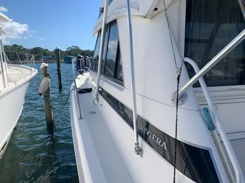 Slide: The Image of 2000 Riviera 34 Convertible yacht docked at a marina. - 5