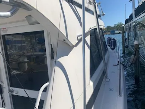 Slide: The Image of Side view of a 2000 Riviera 34 Convertible yacht docked at a marina. - 6