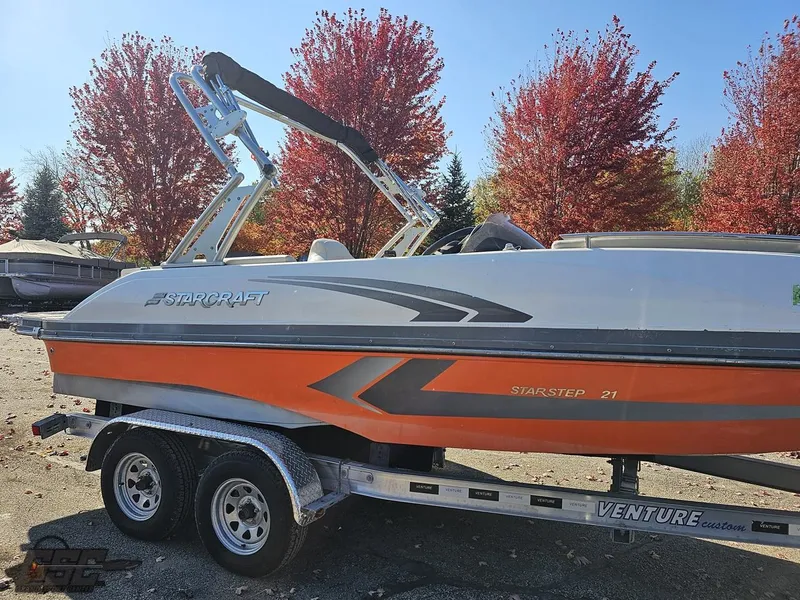 Slide: The Image of 2018 Starcraft Star Step 221 I/O boat on Venture trailer, autumn trees in background. - 18