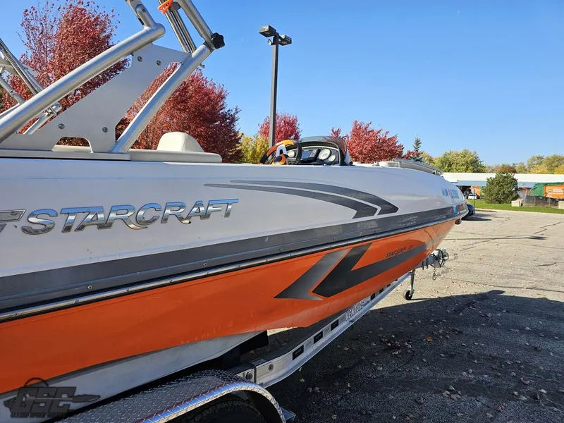 Slide: The Image of 2018 Starcraft Star Step 221 I/O boat with orange and gray accents on a trailer. - 19