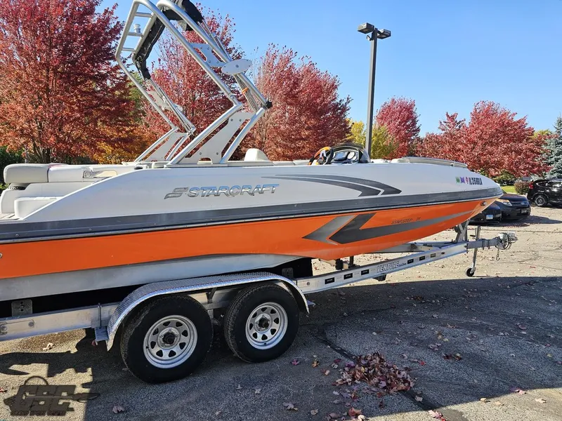 Slide: The Image of 2018 Starcraft Star Step 221 I/O boat on a trailer with autumn trees in the background. - 20