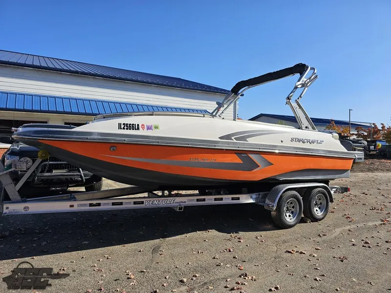 Slide: The Image of 2018 Starcraft Star Step 221 I/O boat on a trailer, orange and white hull. - 6