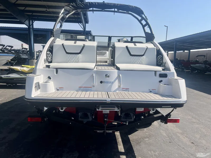 Slide: The Image of 2025 Yamaha Boats 222SE, rear view, in a marina setting. - 4