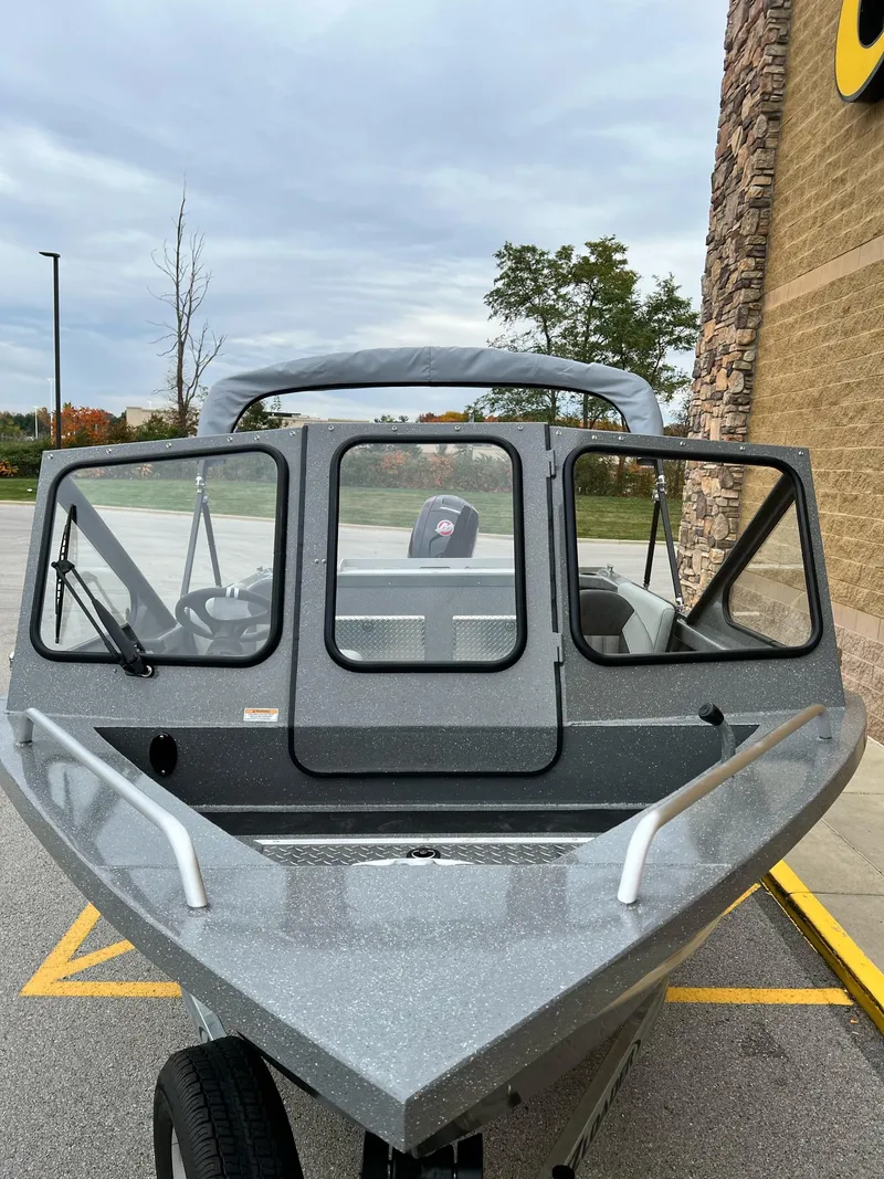 Slide: The Image of 2024 Spartan 185 Astoria boat parked outdoors near a building. - 2