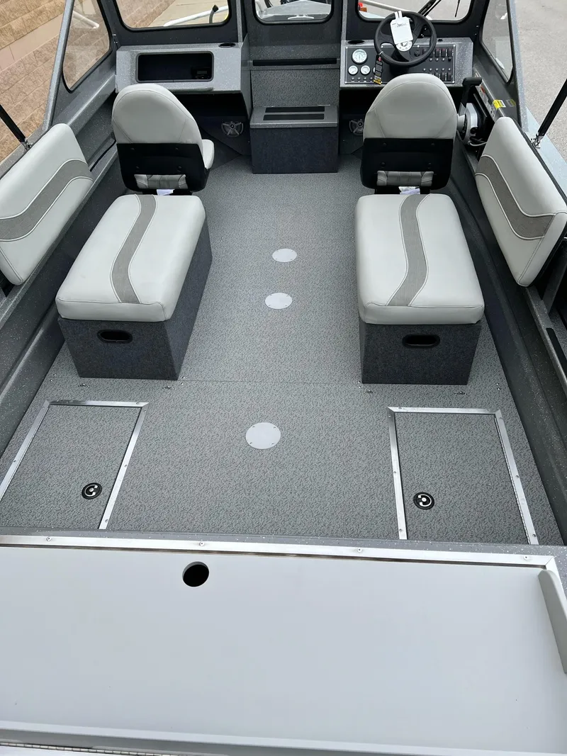 Slide: The Image of 2024 Spartan 185 Astoria boat interior with gray seating and storage compartments. - 3