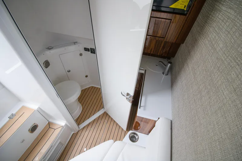 Slide: The Image of Interior of 2025 HCB 42 Lujo boat, featuring a compact bathroom with wooden accents. - 34