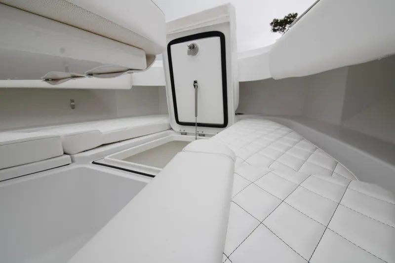 Slide: The Image of 2025 HCB 42 Lujo boat interior with white cushioned seating and storage compartments. - 5