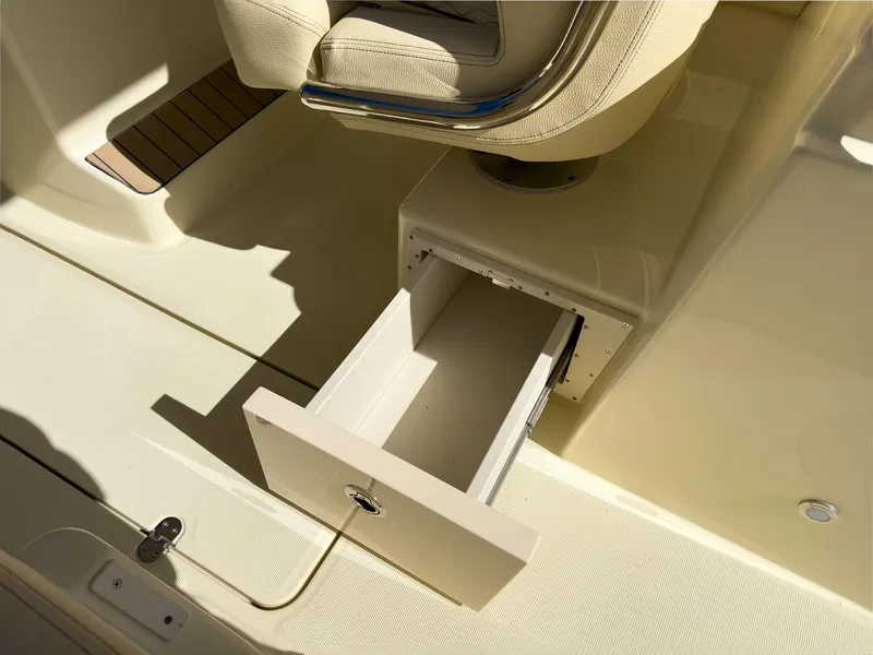 Slide: The Image of 2024 Chris-Craft 24 CALYPSO boat interior with open storage drawer under seat. - 9