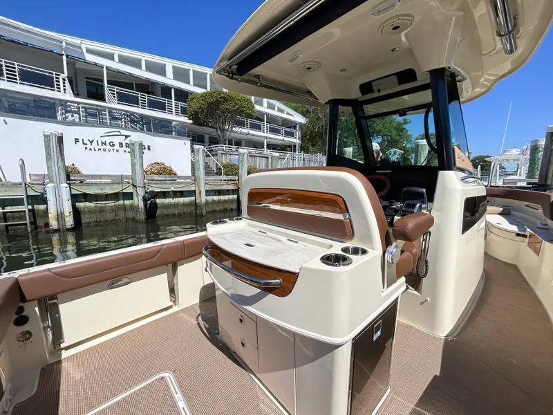 Slide: The Image of 2024 Chris-Craft Catalina boat interior at dock, featuring luxurious seating and helm. - 12