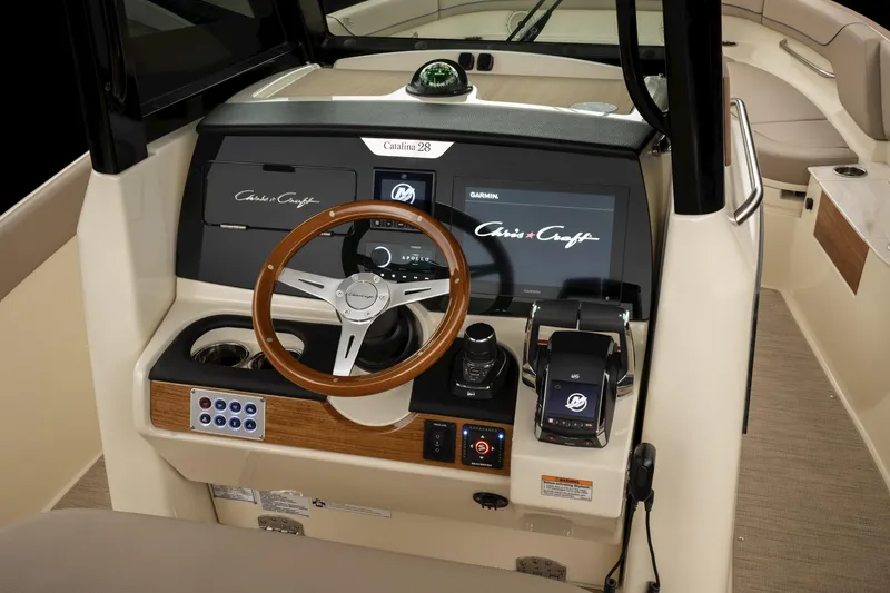 Slide: The Image of 2024 Chris-Craft Catalina boat dashboard with modern controls and wooden steering wheel. - 19