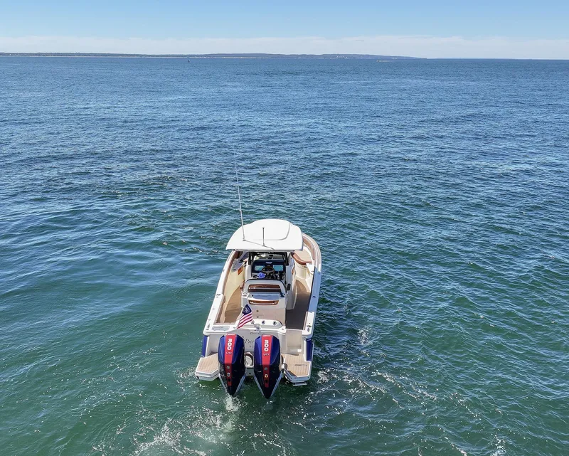 Slide: The Image of 2024 Chris-Craft Catalina boat on open water, rear view with dual engines. - 3