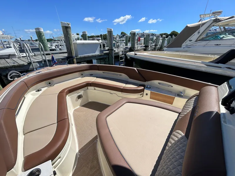 Slide: The Image of 2024 Chris-Craft Catalina boat interior with brown seating at a marina. - 9