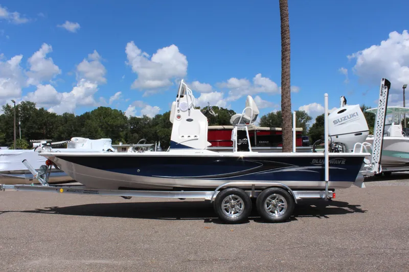 Slide: The Image of 2024 Blue Wave 2200 STL boat on a trailer under a clear blue sky. - 4