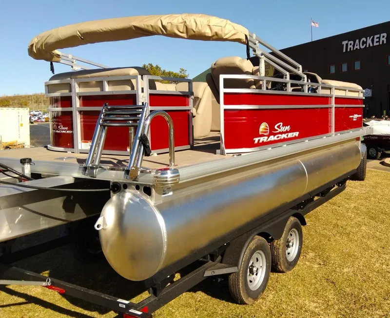 Slide: The Image of 2024 Sun Tracker Party Barge 20 DLX pontoon boat on trailer, red and silver. - 2