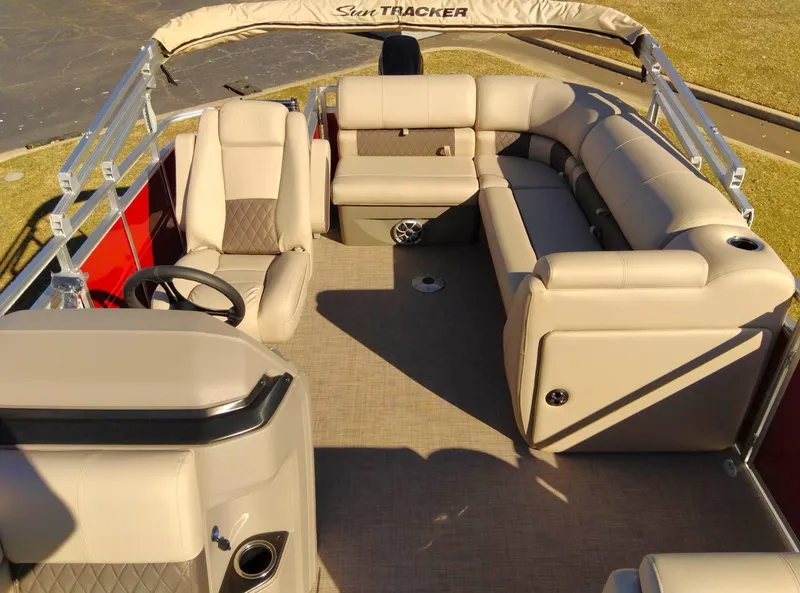 Slide: The Image of 2024 Sun Tracker Party Barge 20 DLX interior with beige seating and spacious layout. - 5