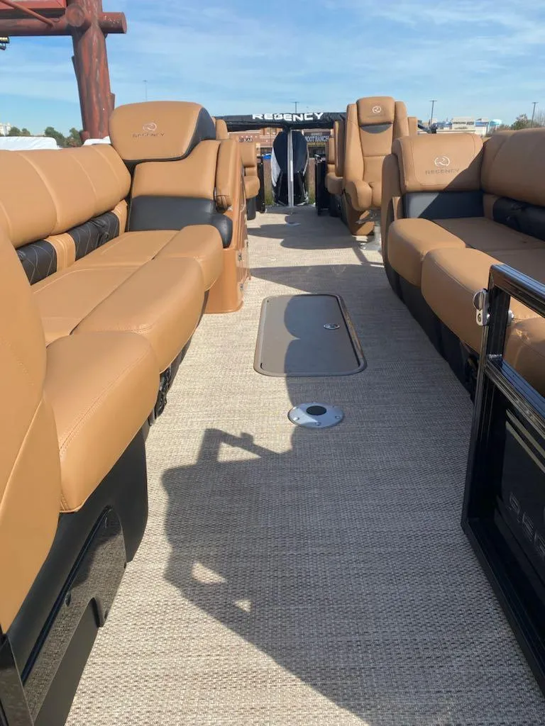 Slide: The Image of 2024 Regency 250 LE3 pontoon boat with luxurious tan seating. - 2