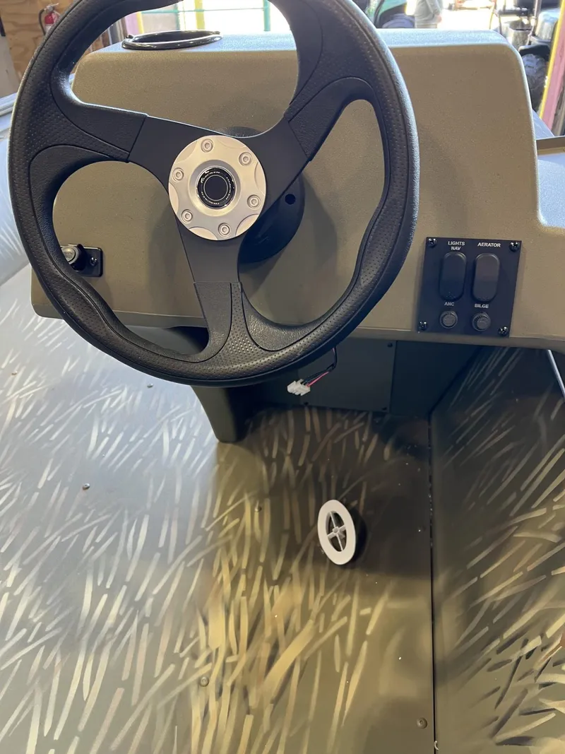 Slide: The Image of 2024 Tracker Grizzly 1648 SC steering console with camo floor design. - 2