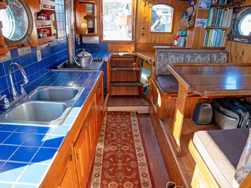 Slide: The Image of Cozy boat interior with blue-tiled kitchen, wooden cabinets, and dining area, Prothero & Franken 1997. - 2