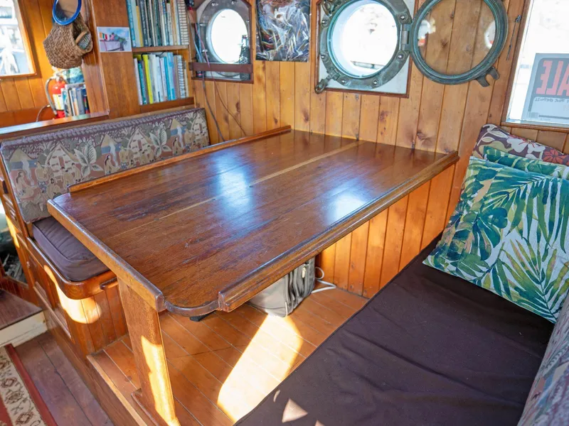 Slide: The Image of Cozy wooden boat interior with portholes, cushioned seating, and bookshelves, Custom Prothero & Franken 1997. - 5