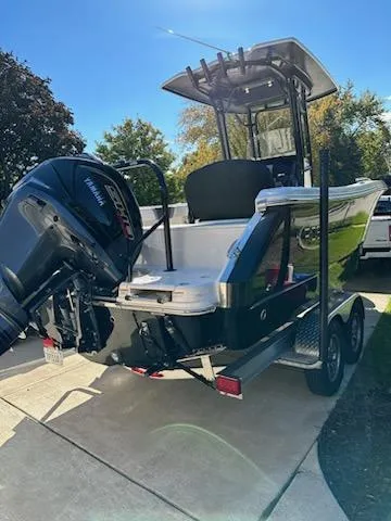 Slide: The Image of 2021 Robalo R230 Center Console boat on a trailer in a driveway. - 3